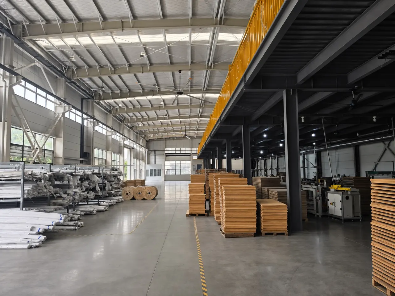 Factory storage area with material rolls, pallets, and finished goods